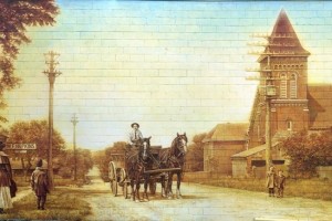 painted mural on brick wall showing a horse carriage and people dressed on old clothes
